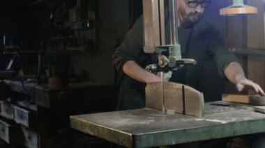 Şerit testere ile ahşap bir parça keser bir marangoz üzerinde toplam alanı