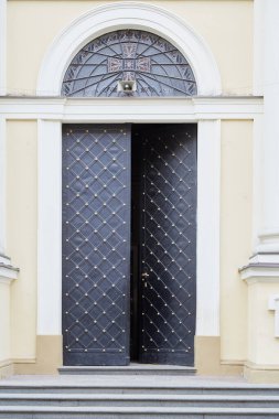 Eski metal, kemerli siyah bir kapı.