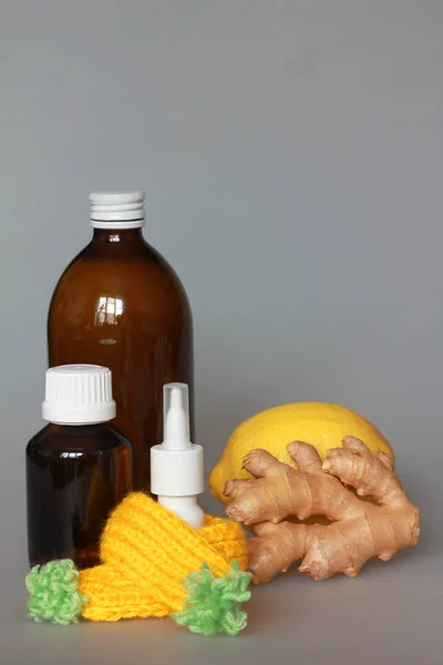 syrup in a bottle of dark glass with lemon and ginger on a gray background