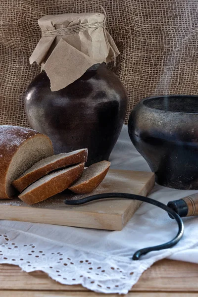 Ülke kahvaltı - ahşap masanın üzerine dilimlenmiş ekmek, dumanı tüten bir pot ve bir sürahi