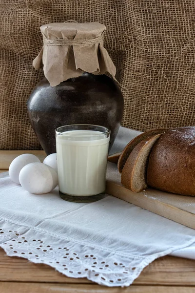 Country breakfast - bread, eggs, milk on the wooden table