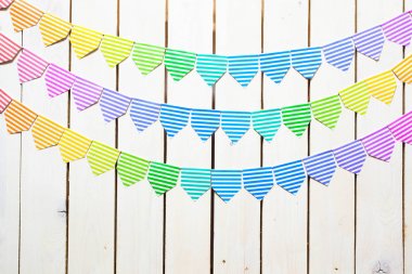 Renkli bayraklar garland. Arka plan beyaz ahşaptır.