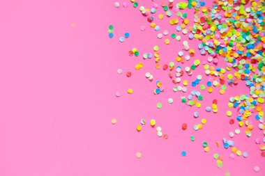 Çerçeve renkli konfeti yaptı. Pembe bir arka plan. 