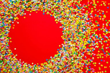 Çerçeve renkli konfeti yaptı. Kırmızı bir arka plan. 