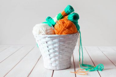 Yün iplik bobinleri ve tangles beyaz sepet içinde. Yapılan bir tablo