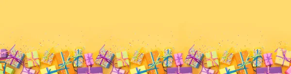 Colored gift boxes with colorful ribbons. White background. Long — Stock Photo, Image