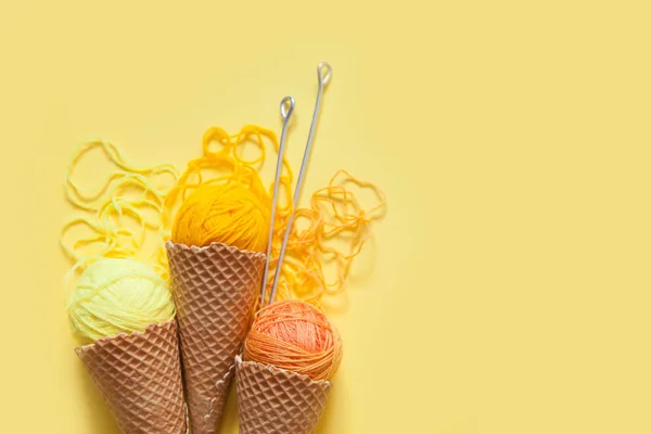 Balls of yarn lie in a waffle cone for ice cream. Coloured wool. — Stock Photo, Image