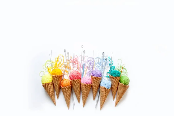 Balls of yarn lie in a waffle cone for ice cream. Coloured wool. — Stock Photo, Image