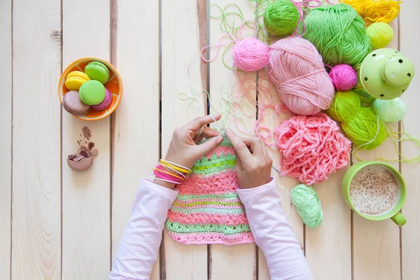 A woman knits a bright colored canvas with spokes. Hands close-u — Stock Photo, Image