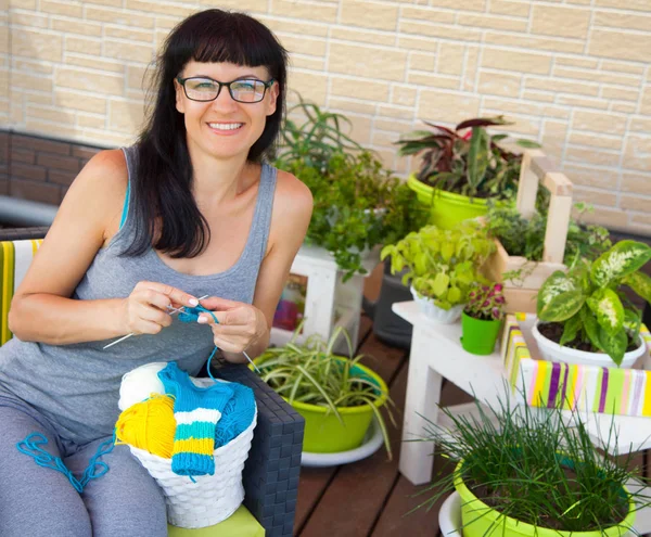 Una joven sonriente teje los calcetines de punto con lana de colores —  Fotos de Stock