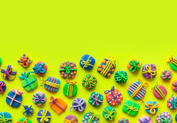 Many small gifts from plasticine. Yellow background. — Stock Photo, Image