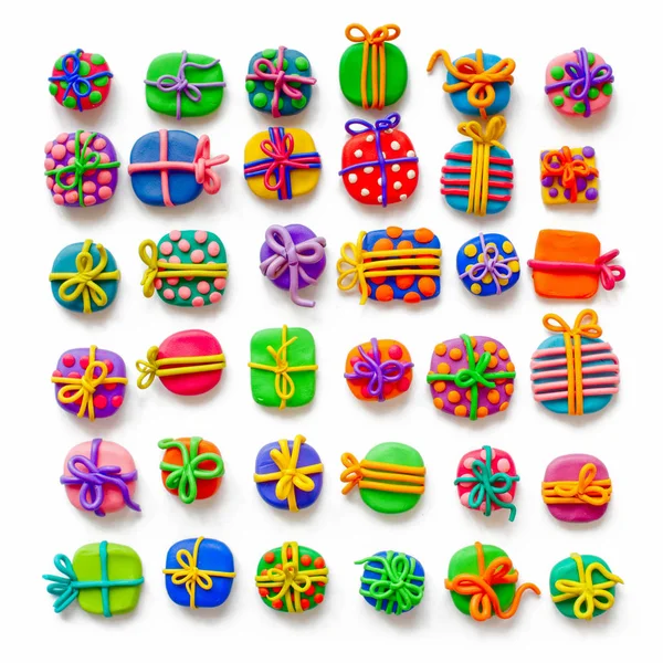 Many small gifts from plasticine. White background. — Stock Photo, Image