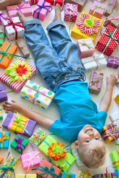 아이 선물 흩뿌려져 있다. 소년, 바닥에 거짓말 하 고 — 스톡 사진
