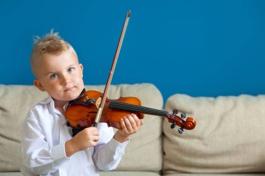 Çocuk keman çalıyor. Çocuk müzik eğitimi.