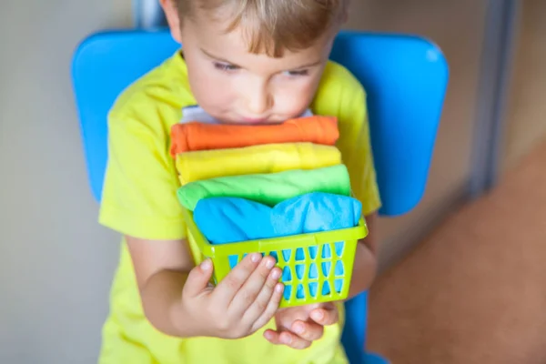 El niño guarda sus cosas. El chico pone las camisetas en un cajón — Foto de Stock