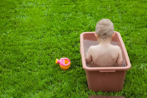 Yeşil çimenlerin üzerinde banyoda küçük çocuk yıkar. 4-5 / çocuk — Stok fotoğraf