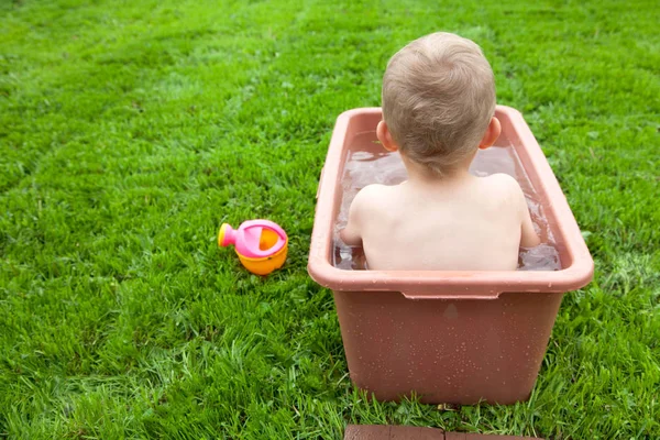 Yeşil çimenlerin üzerinde banyoda küçük çocuk yıkar. 4-5 / çocuk — Stok fotoğraf