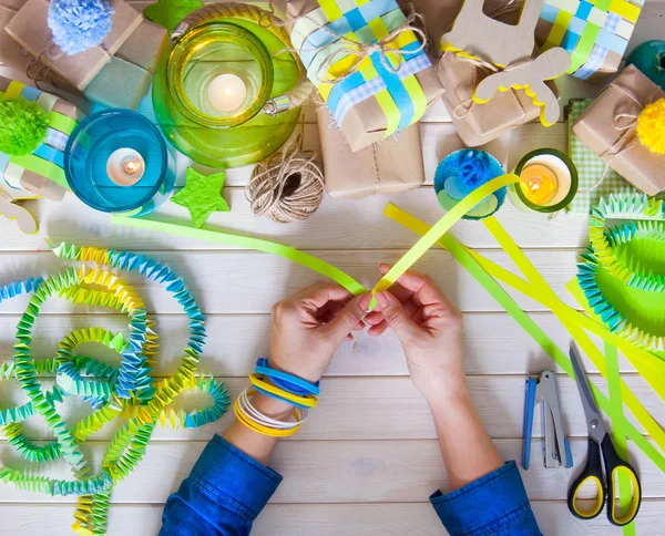 Bir kadın bir festival çelenk yapıyor. Mavi ve yeşil renkler.