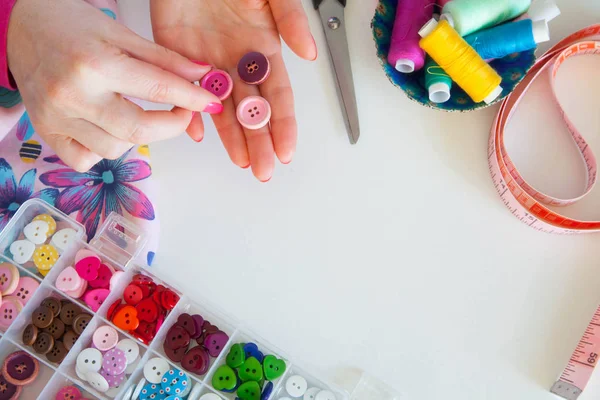 Female hands and accessories for sewing. Buttons, fabric and thr — Stock Photo, Image