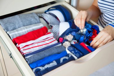 Düzgünce katlanmış giysileri Çekmeceli aksesuarları ile. Mari