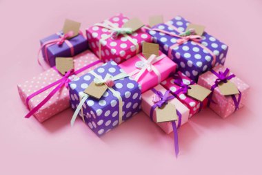 Renkli hediye kutuları renkli şeritler. Pembe bir arka plan. Hediyeler