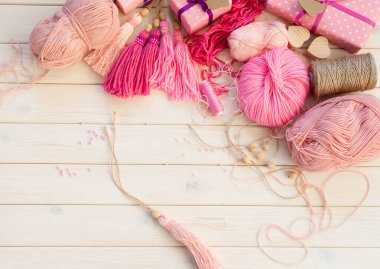 Pembe püsküllü. Beyaz ahşap arka plan. Kadın el sanatları. ,