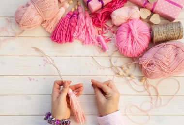 Pembe püsküllü. Beyaz ahşap arka plan. Kadın el sanatları. ,