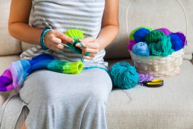 Gri elbiseli bir kadın renkli iplik gelen çorap örme. C topları