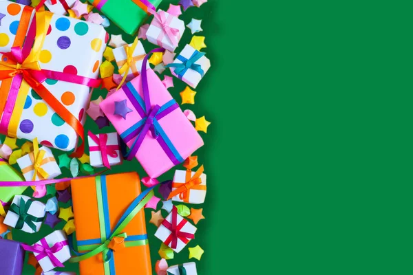 Renkli hediye kutuları renkli şeritler. Yeşil arka plan. Hediyelik