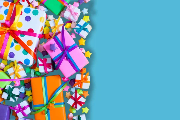 Renkli hediye kutuları renkli şeritler. Mavi arka plan. Hediyeler