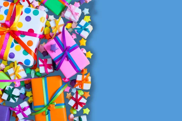 Renkli hediye kutuları renkli şeritler. Mavi arka plan. Hediyeler