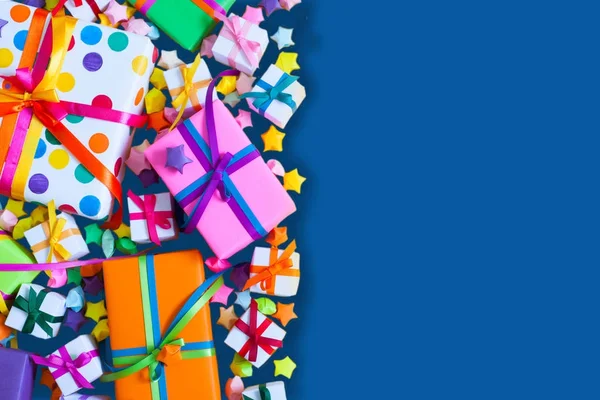Renkli hediye kutuları renkli şeritler. Mavi arka plan. Hediyeler