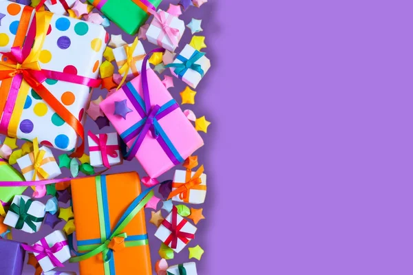 Renkli hediye kutuları renkli şeritler. Lila arka plan. Hediyelik