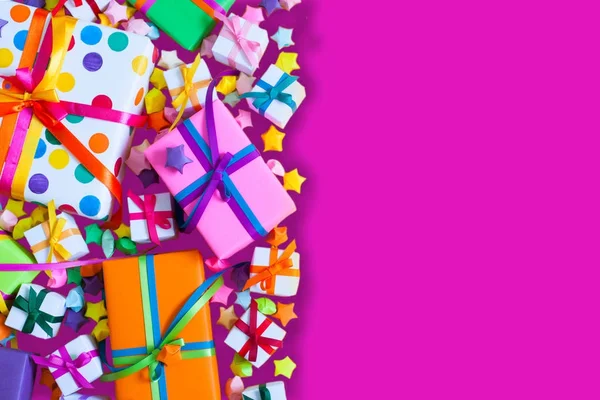 Renkli hediye kutuları renkli şeritler. Pembe bir arka plan. Hediyeler