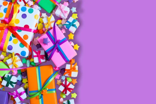 Renkli hediye kutuları renkli şeritler. Lila arka plan. Hediyelik