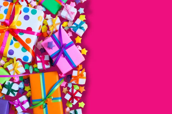 Renkli hediye kutuları renkli şeritler. Pembe bir arka plan. Hediyeler