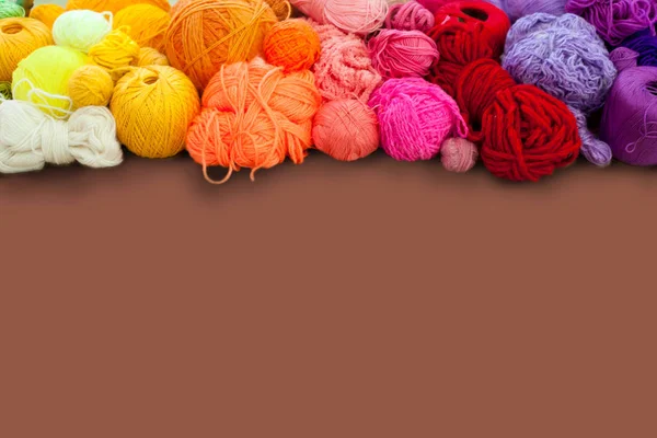 Colorful yarn stacked in a series of colors. Background brown. B — Stock Photo, Image