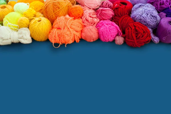 Colorful yarn stacked in a series of colors. Background blue. Ba — Stock Photo, Image