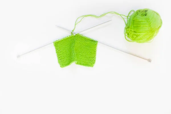 Вязаное вязаное зелёное. Ярма для вязания зеленого цвета. Белый фон — стоковое фото