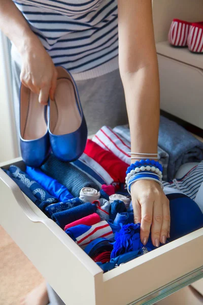 Düzgünce katlanmış giysileri Çekmeceli aksesuarları ile. Mari