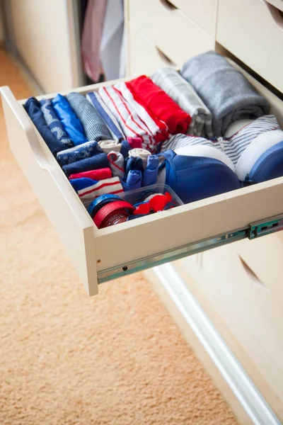 Netjes gevouwen kleding met accessoires in de commode — Stockfoto