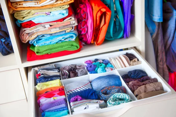 Neatly folded clothes with accessories in chest of drawers — Stock Photo, Image