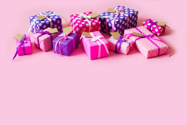 Gekleurde geschenkdozen met kleurrijke linten. Roze achtergrond. Geschenken — Stockfoto