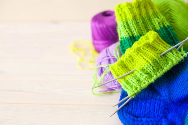 Gri elbiseli bir kadın renkli iplik gelen çorap örme.