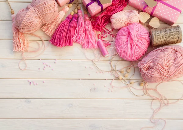 Pink tassels. Background of white wood. Women's handicrafts. The — Stock Photo, Image