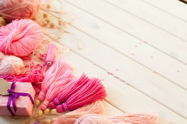 Pembe püsküllü. Beyaz ahşap arka plan. Kadın el sanatları. ,