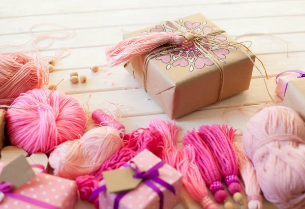 Pink tassels. Background of white wood. Women's handicrafts. The — Stock Photo, Image