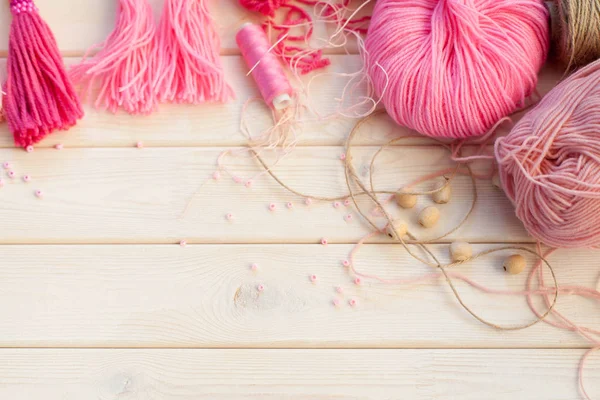 Pembe püsküllü. Beyaz ahşap arka plan. Kadın el sanatları. ,