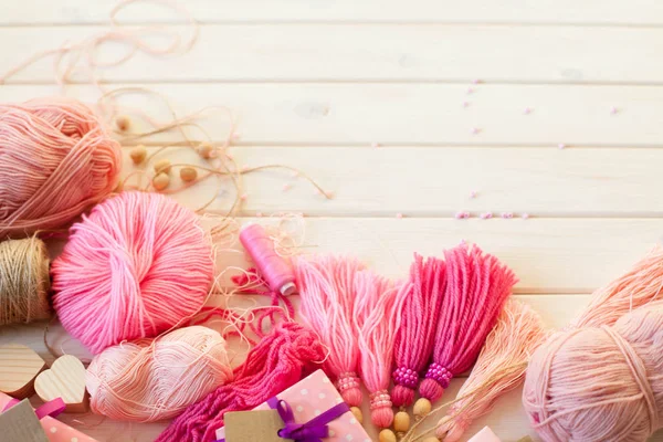 Pembe püsküllü. Beyaz ahşap arka plan. Kadın el sanatları. ,