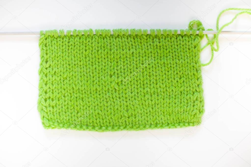 Knitted knitted green. Yarn for knitting green. White background